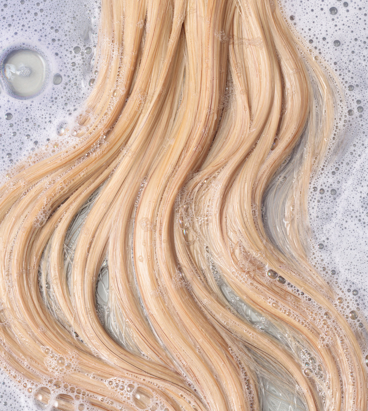 Close up of blonde soapy hair in water