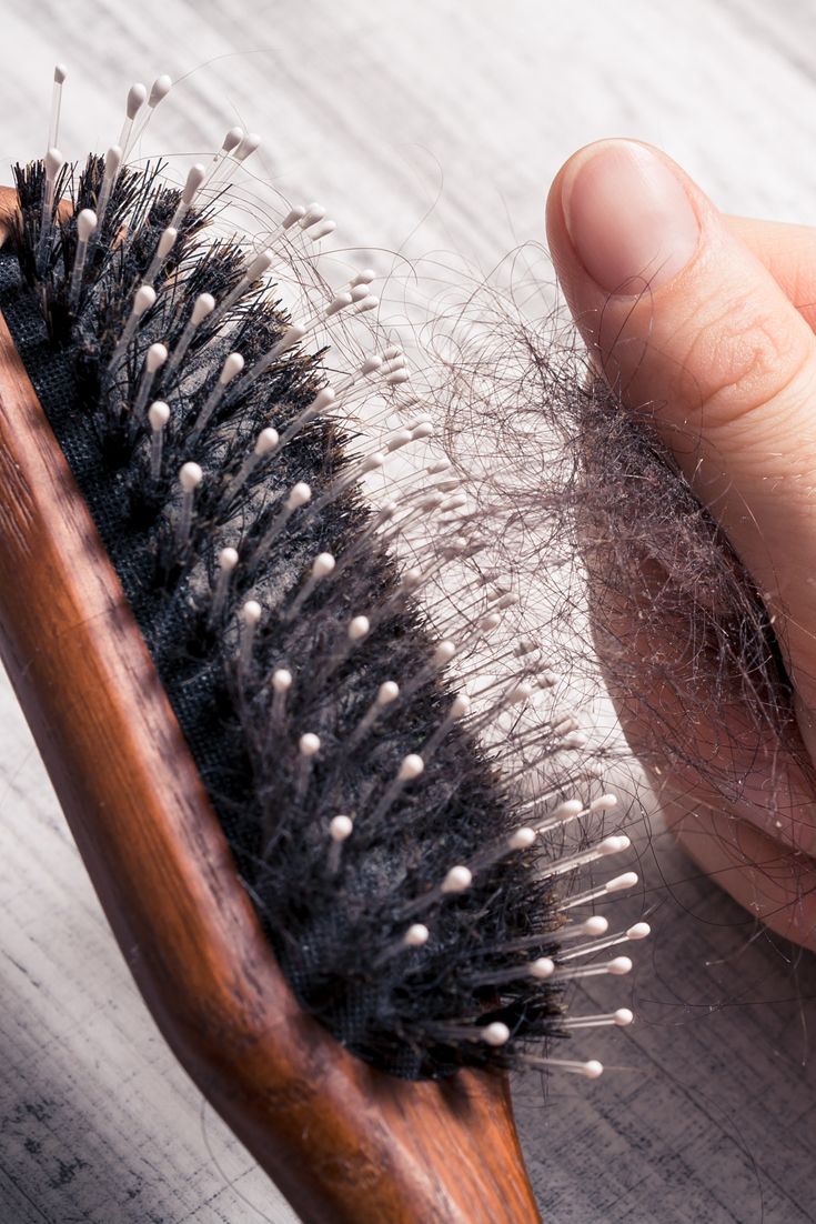 Image of a hand grabbing a clumb of hair from a hair brush