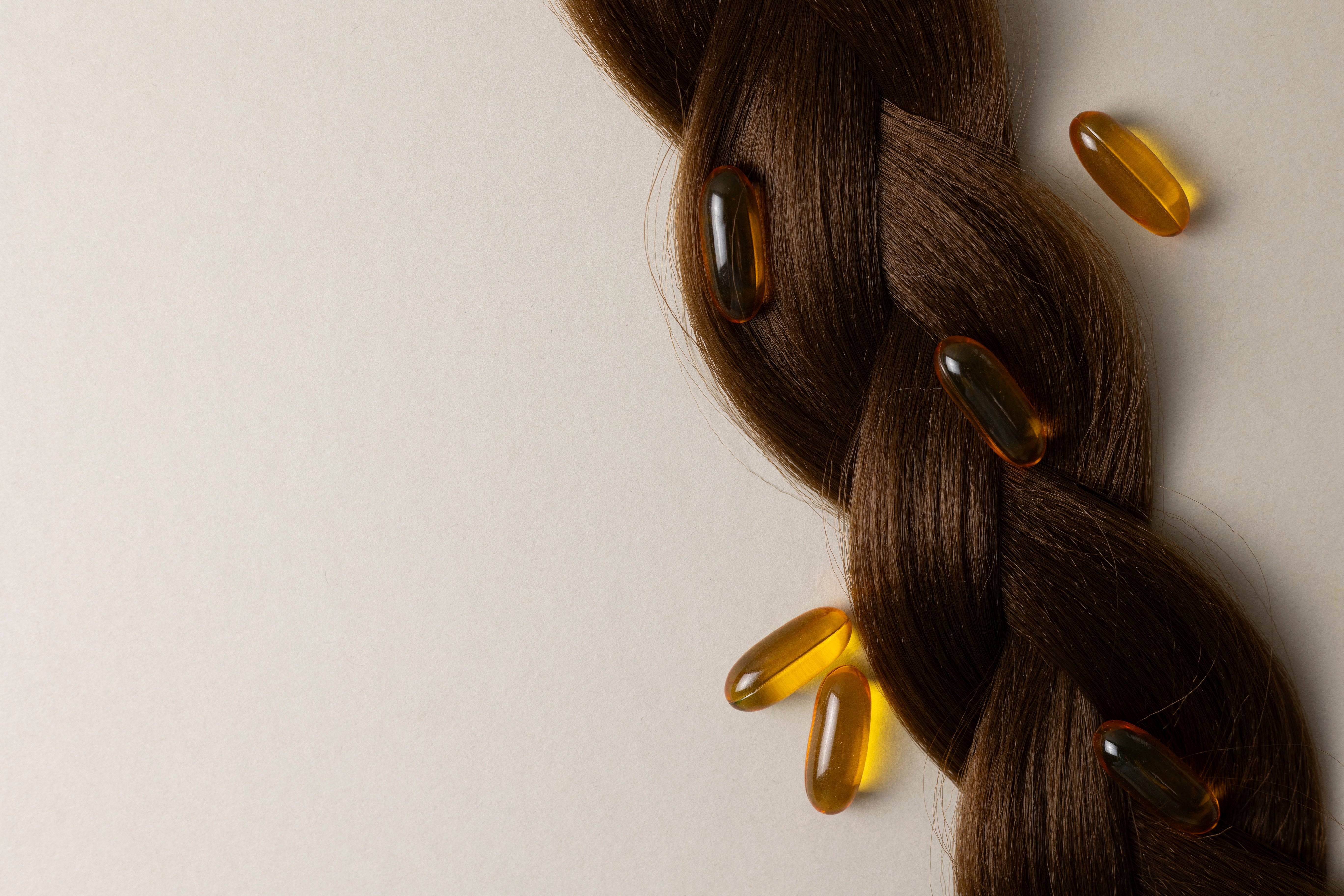 Close up of supplements lying on top of dark brown plaited hair
