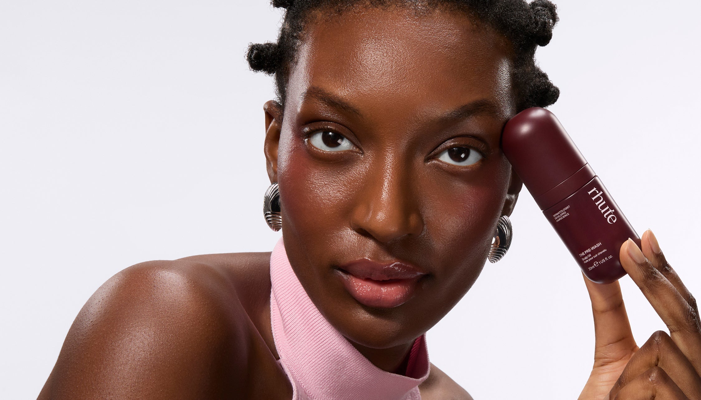 Woman holding rhute's hair serum product