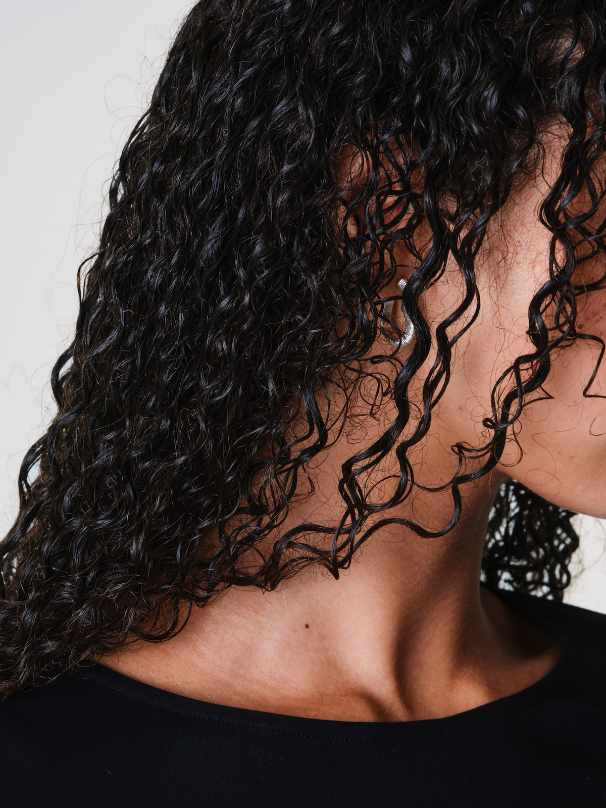 Woman with black coily hair close up side profile